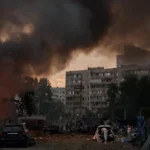 Зруйновані багатоповерхівки Києва через повномасштабну війну з димом та уламками
