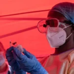 Медик у засобах захисту готує вакцину rVSV-ZEBOV для випробування від Еболи в Конго