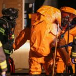Рятувальники в захисних помаранчевих костюмах та спорядженні на місці інциденту вночі